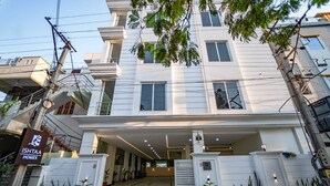 Un moderno edificio residenziale a due piani con ingresso coperto e piante in vaso.