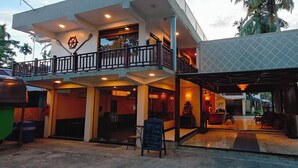 A two-story building with a balcony, a signboard, and a covered outdoor seating area. - ARINA ISLAND RESORT-A BERGAMONT GROUP (Port Blair)