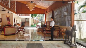 A spacious lobby with a high ceiling, wooden paneling, and a central seating area with wicker furniture. - ARINA ISLAND RESORT-A BERGAMONT GROUP (Port Blair)