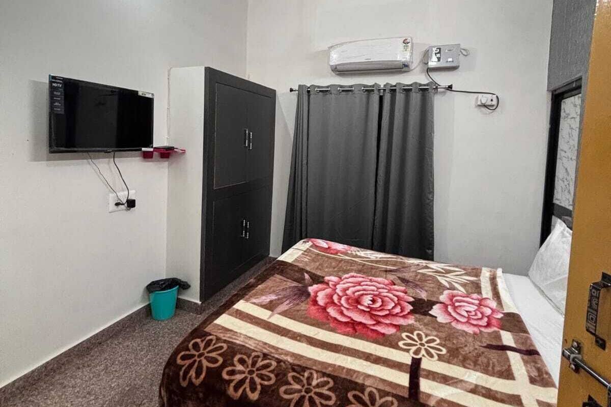 Camera da letto con un letto, una ventola a soffitto, un condizionatore d'aria, una TV, un armadio e un cestino per i rifiuti.