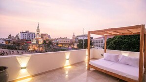 Ein Balkon mit einer Holzpergola und einem weißen Sofa.