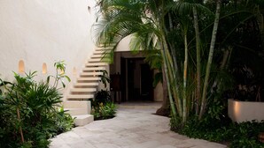 A pathway leading to a staircase surrounded by lush greenery and a modern building facade. - 9 Bedroom Luxury Villa in Old City (Cartagena)