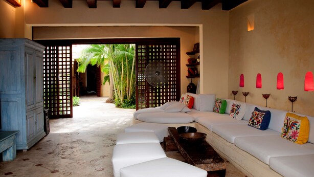A modern living room with a white sectional sofa, a wooden coffee table, and a decorative wall with red lighting. - 9 Bedroom Luxury Villa in Old City (Cartagena)