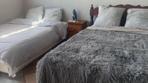 Une chambre avec deux lits, une table de chevet et une fenêtre.