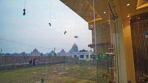 A view from a hotel room with a glass wall, a tiled floor, and a reception area visible through the glass. - Prapti resort (Kanthi)