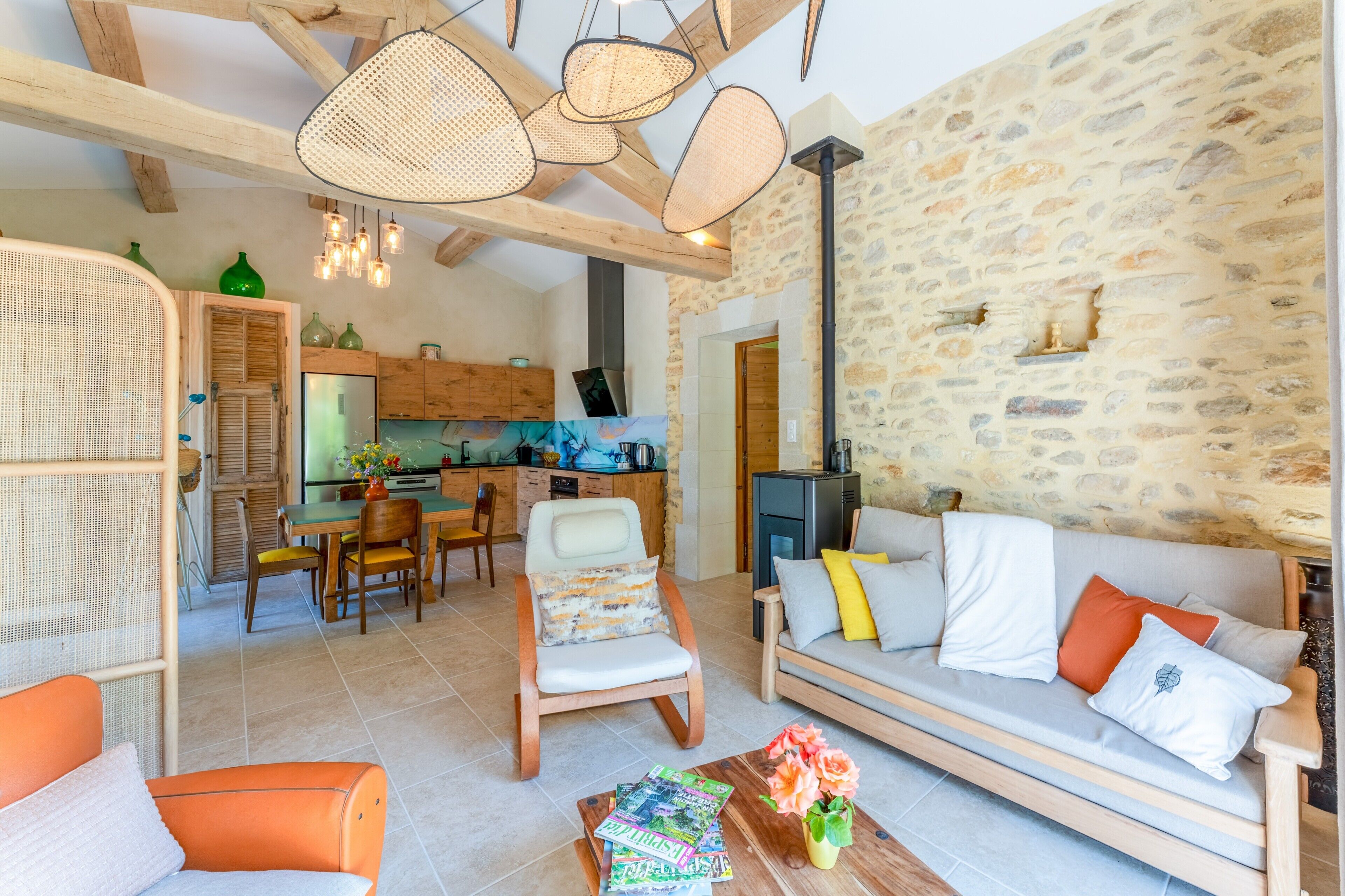 A cozy living room with a sofa, chairs, a coffee table, and a dining area with a table and chairs.