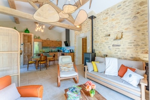 Un salon confortable avec un canapé, des fauteuils, une table basse et un coin repas comprenant une table et des chaises.