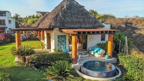 A thatched-roof structure with a pool and outdoor seating area. - Casa Irekua Luxury beachfront retreat (Joluta)