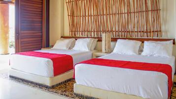 Habitación de hotel con dos camas, cada una con ropa de cama blanca y detalles rojos, un cabecero de madera y un piso con estampado.