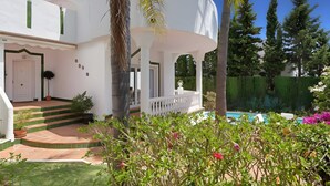 Un bâtiment blanc avec une piscine, des marches et une clôture blanche.