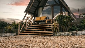 A modern house with a triangular roof, a staircase leading to a porch, and a view of the sky. - Cozy A-Frame Retreat in Zanzibar Nungwi Leo Glamping (Nungwi)