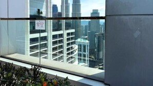A balcony with a view of the Petronas Towers and surrounding buildings. - The Platinum Suites KLCC by Moonlight (Kuala Lumpur)