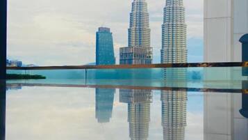 Un interior moderno con un amplio estanque reflectante y vistas a las Torres Petronas.