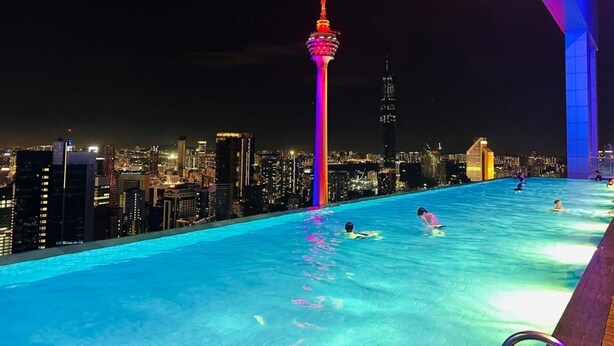 A rooftop infinity pool with a city skyline in the background, including a prominent tower. - The Platinum Suites KLCC by Moonlight (Kuala Lumpur)