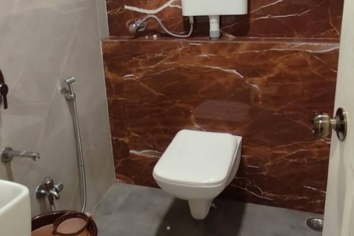 Une salle de bain avec des toilettes, un lavabo et une douche.