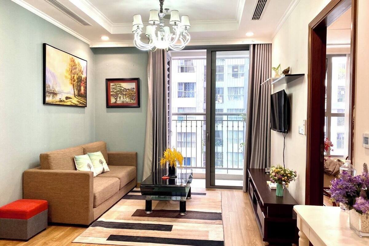 Ein modernes Wohnzimmer mit einer Couch, einem Couchtisch und einem an der Wand montierten Fernseher.