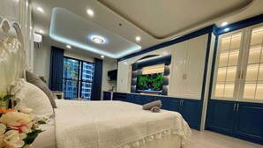 A bedroom with a large bed, a TV, and a view of the city. - HMH- Vinhomes TIme City - Park Hill  (Hanoi)