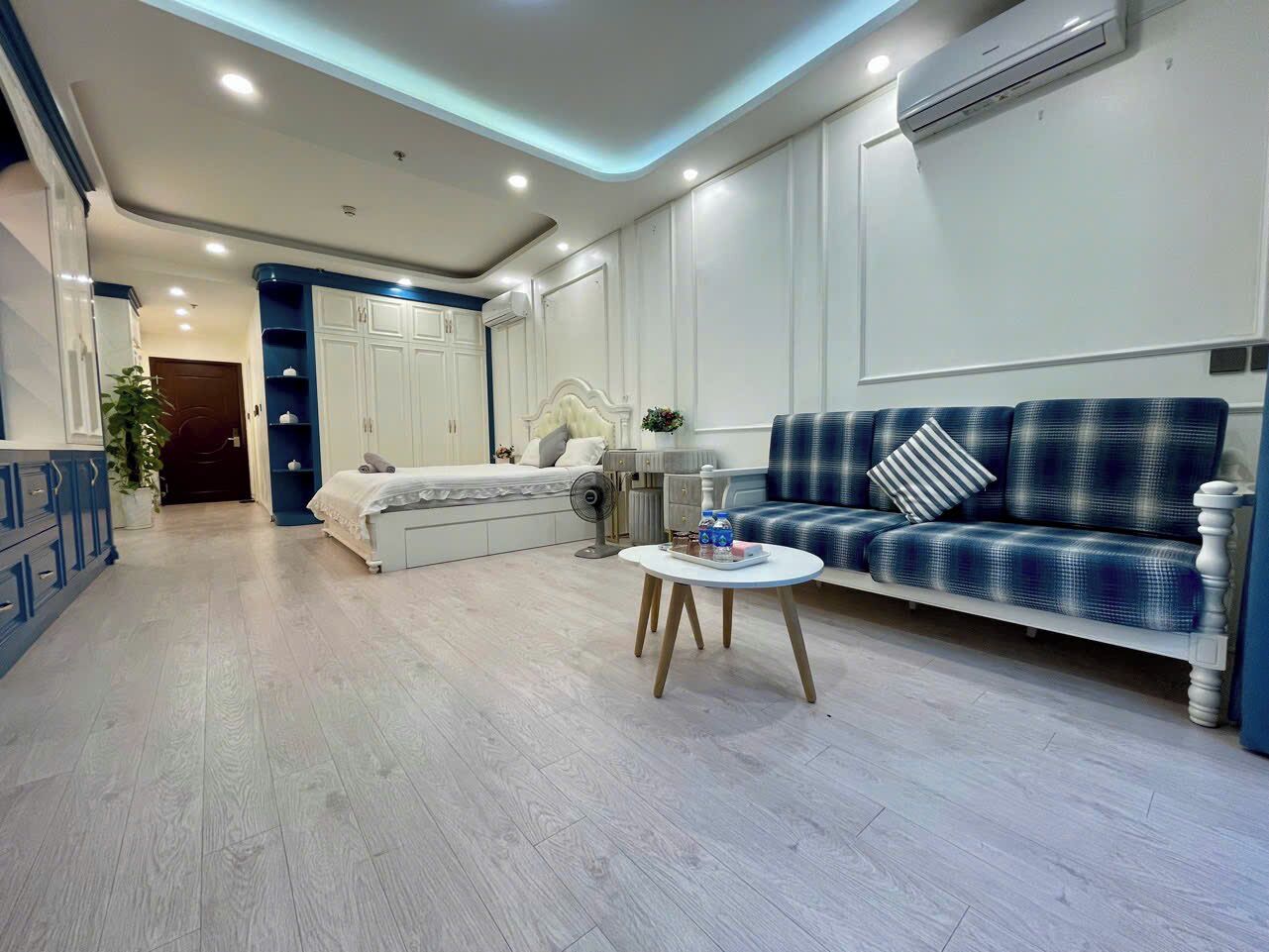 Una sala de estar moderna con un sofá, una mesa de centro y una cama con cabecera.