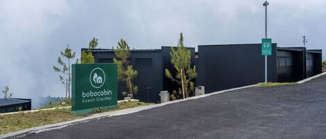 A Bobocabin Kawah Ciwidey sign with a modern building in the background.