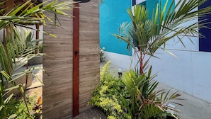 A wooden door with a black handle, a thatched roof structure, and lush tropical plants. - Puerto Vallarta Calm Getaway with Pool  (Puerto Vallarta)