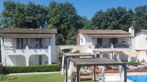 A villa with a swimming pool, outdoor seating, and a well-maintained lawn. - Zografia Apartments (Corfu)