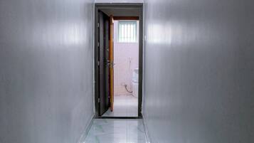 A hallway with white walls and a tiled floor.