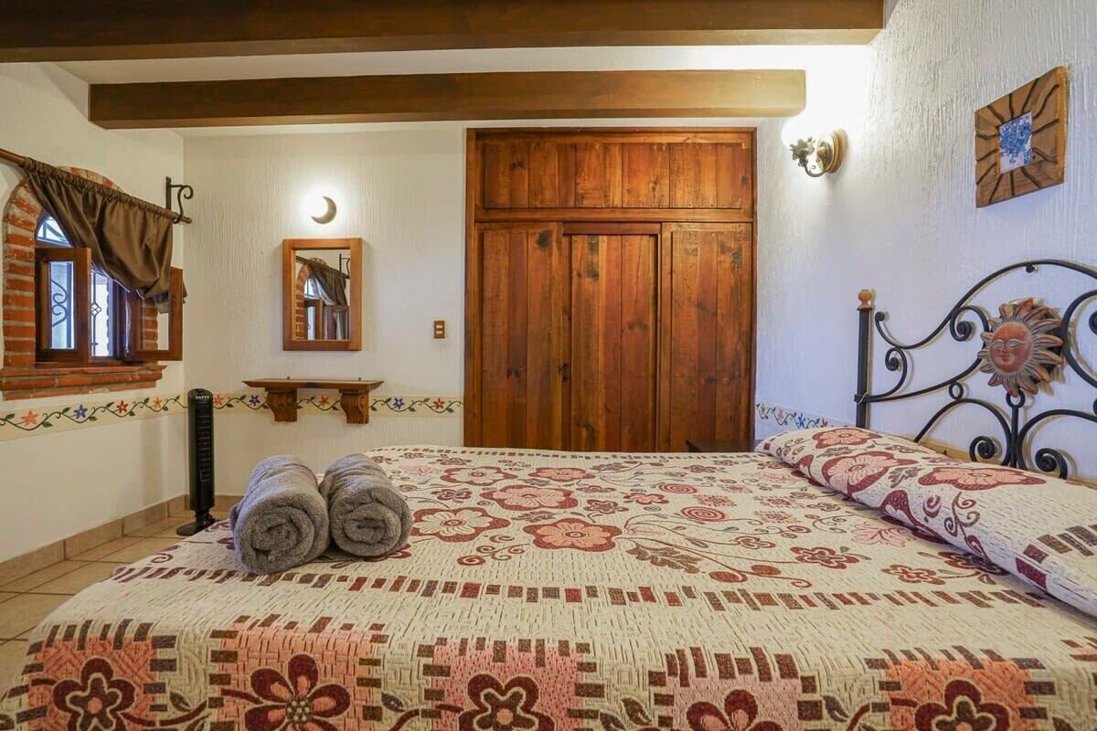Un dormitorio con una cama grande, un armario de madera y una pequeña estantería.