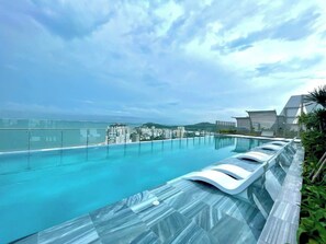A rooftop infinity pool with a clear view of the ocean and cityscape. - The Sóng Apartment – Near the beach (Ho Chi Minh City)