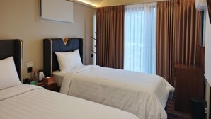 A hotel room with two beds, a flat-screen TV mounted on the wall, and a window with curtains. - Nusantara Cabin and Coffee (Sepaku)