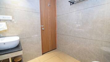 A bathroom with a wooden door, a white sink, and a toilet.