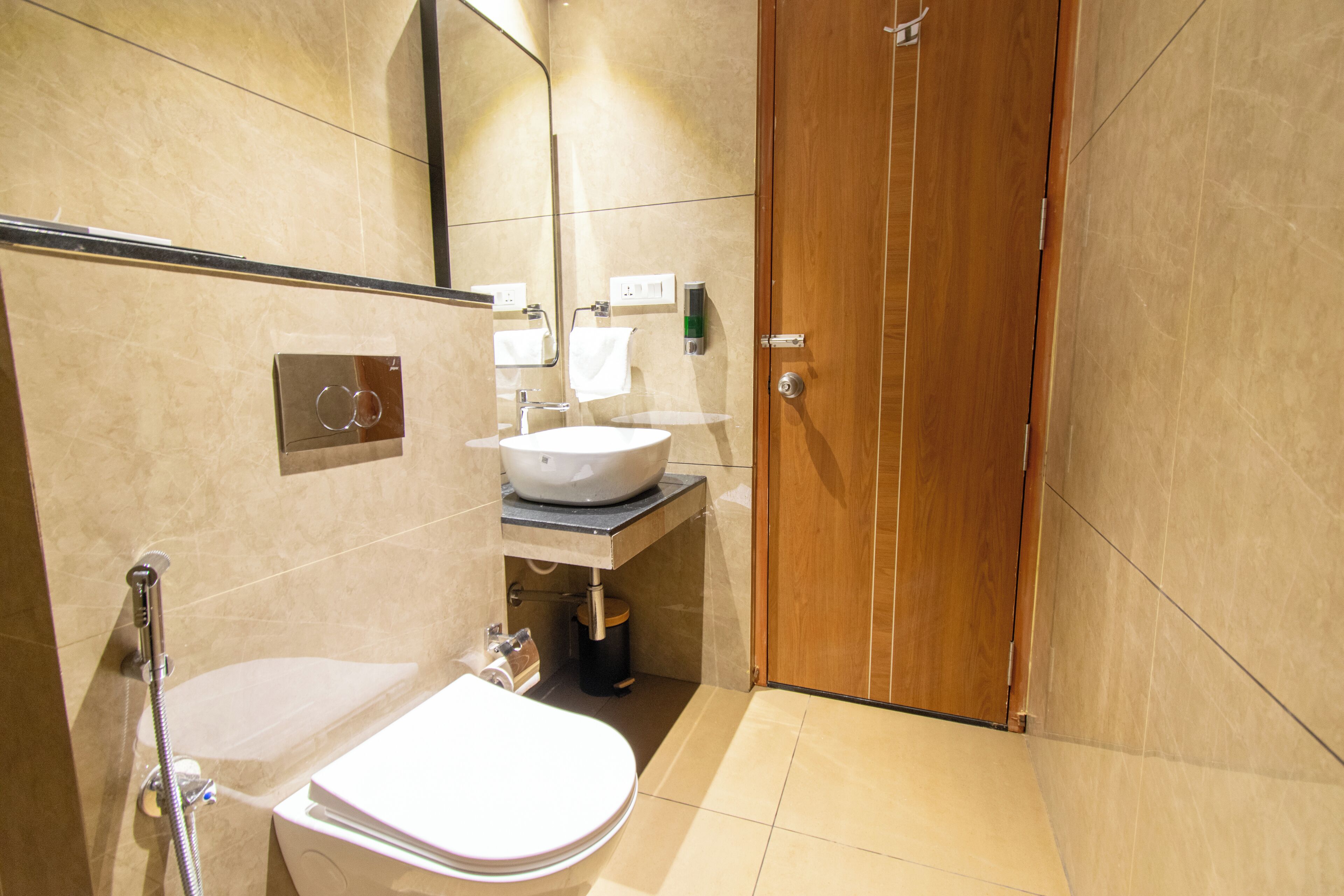 Een moderne badkamer met toilet, wastafel en douche.