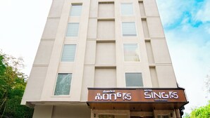 A hotel building with multiple windows and a signboard that reads "HOTEL SING 65". - Hotel Sing 65 (Bengaluru)