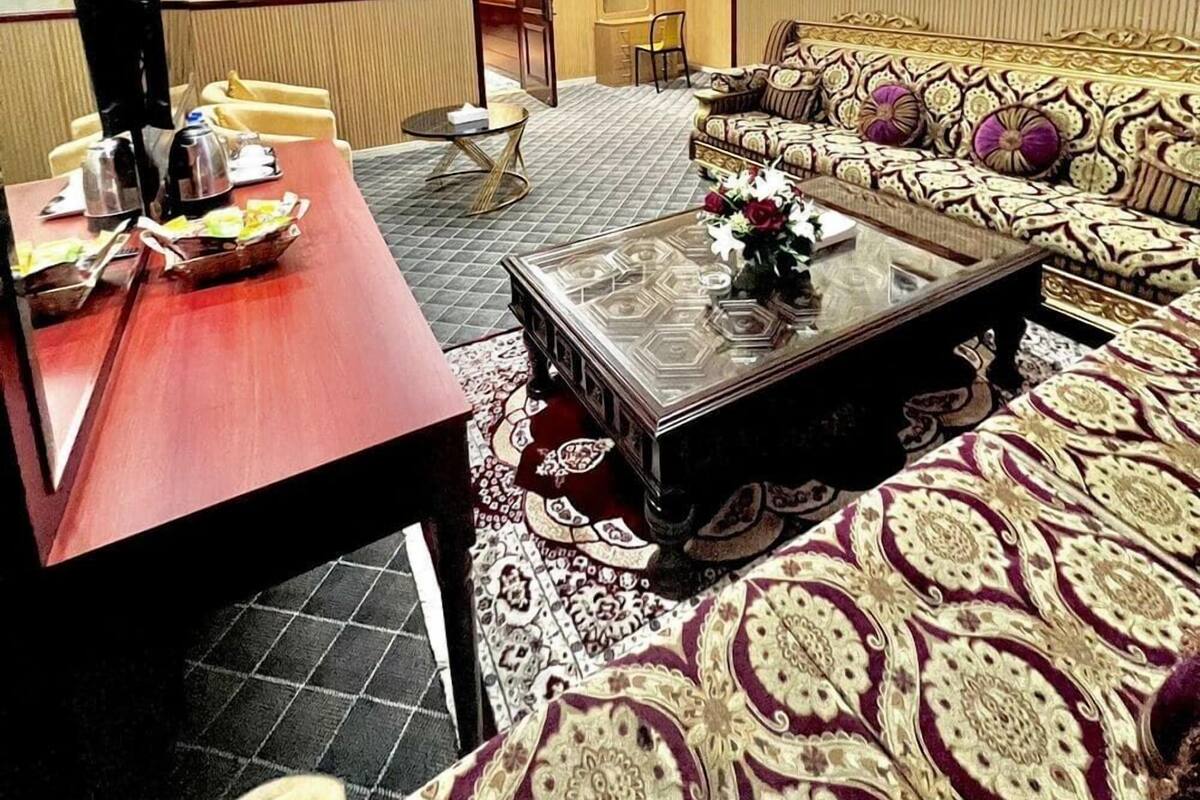 A living room with a sofa, coffee table, and a dining area with chairs and a table.
