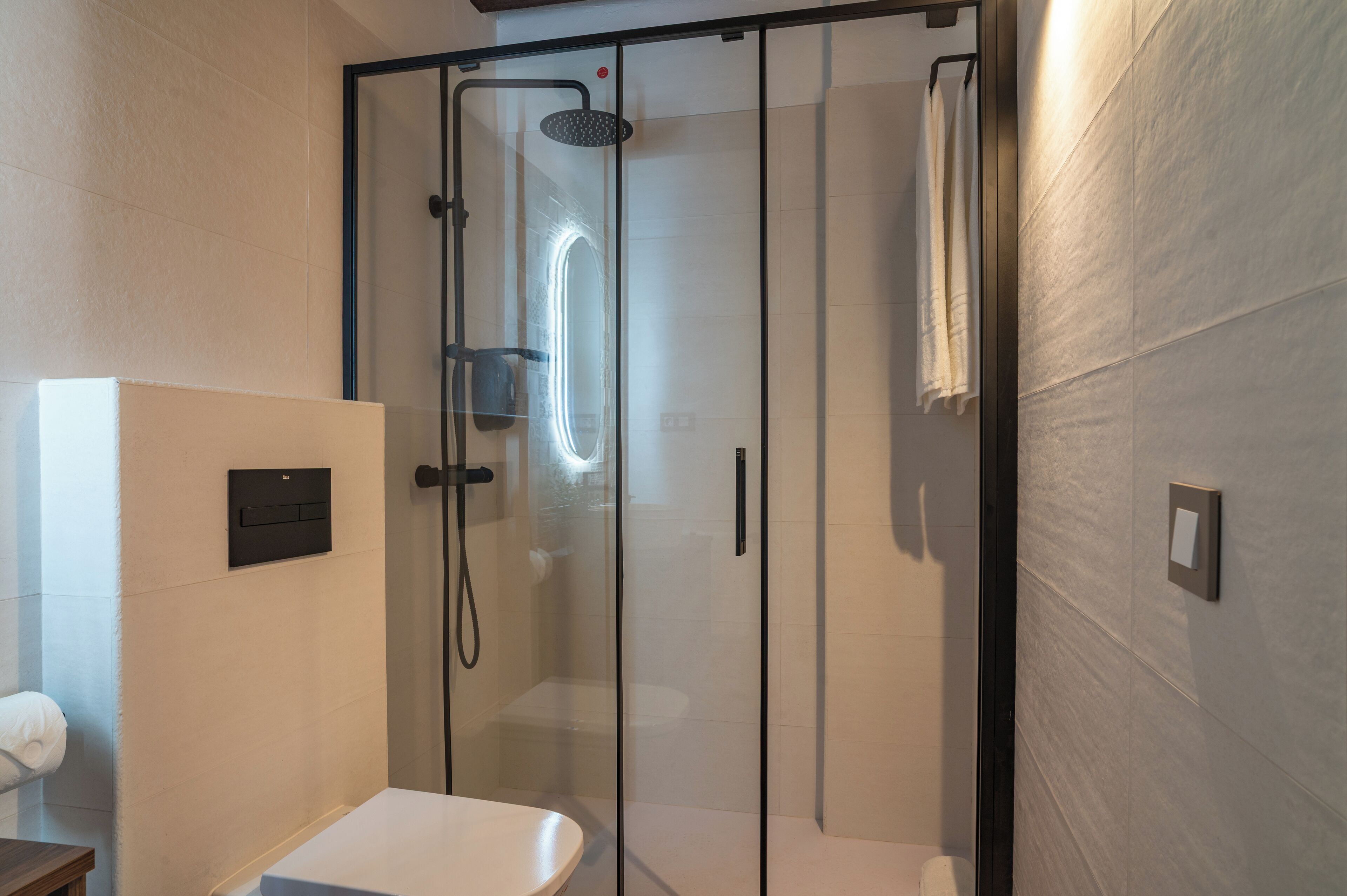 Un baño moderno con ducha acristalada, inodoro y lavabo.