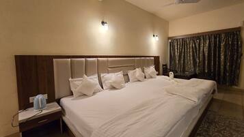 A large bed with a headboard, a bedside table with a lamp, and a ceiling fan.