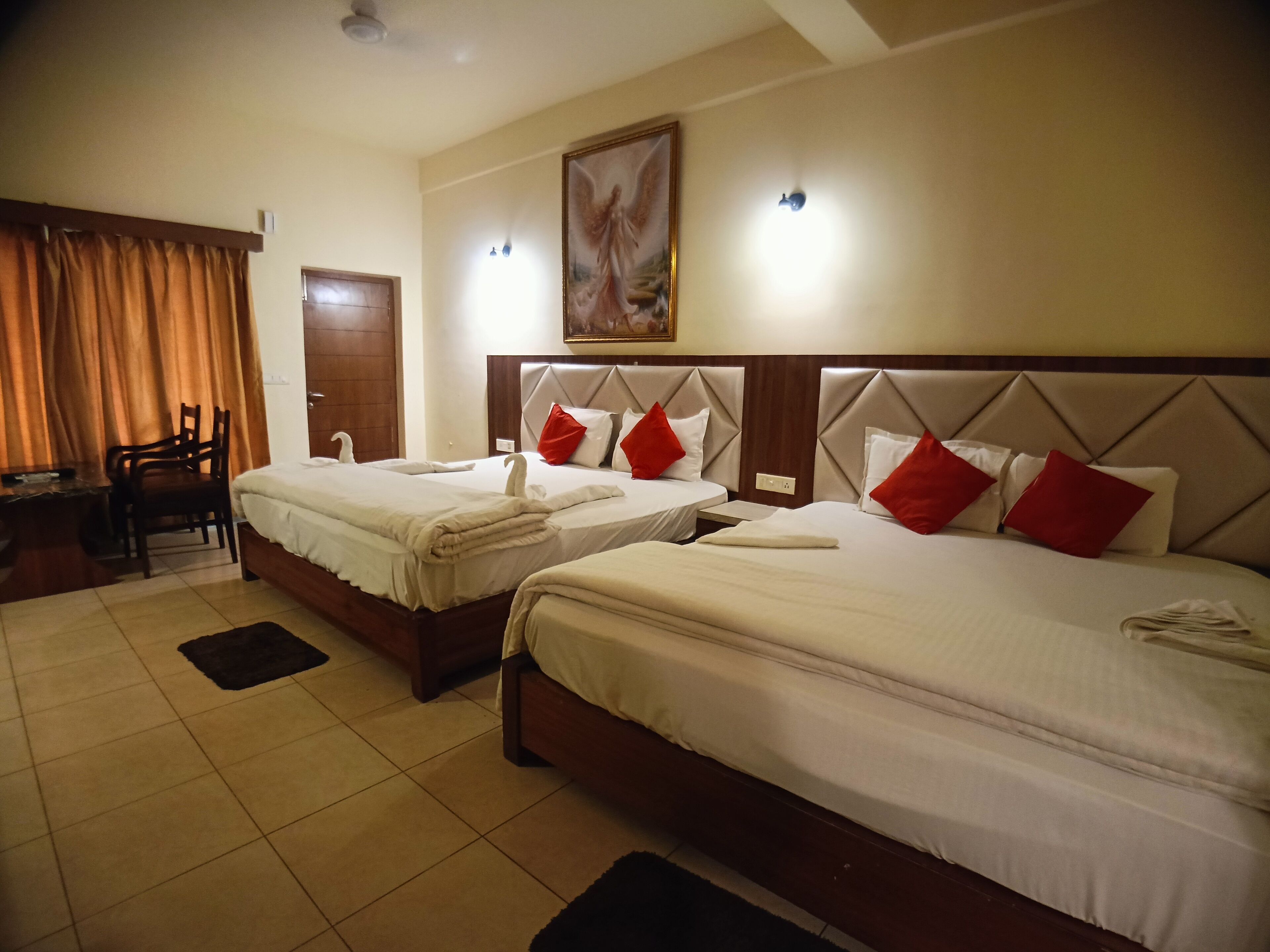 A hotel room with two beds, a desk, and a chair.