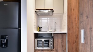 A compact kitchen with a built-in coffee maker, a toaster oven, and a microwave. - W*| Amazing 1BR w/ Beautiful view in Virrey (Bogotá)