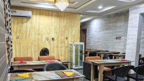 A conference room with a modern design, featuring a chandelier, marble flooring, and wooden panel walls. - Esthercy Hotels Ltd Lagos (Lagos)