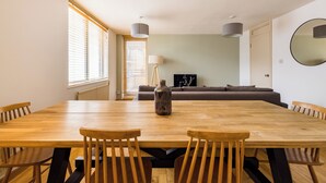 Un grand espace dédié à la salle à manger, avec une table et des chaises en bois, un canapé et une lampe.