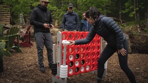 A group of people playing a game involving a red and white obstacle course in a wooded area. - Cozy Yurt in the Woods (Sainte-Agathe-des-Monts)