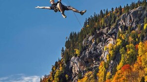 A person bungee jumping from a cliff with autumn foliage below. - Cozy Yurt in the Woods (Sainte-Agathe-des-Monts)