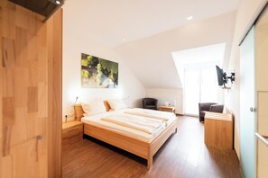 A modern bedroom with a wooden bed, a desk, and a chair. - Weingut & Gästehof Borst (Nordheim a. Main)