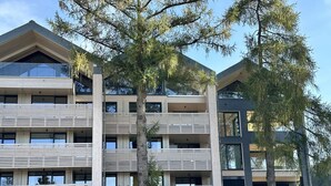 Un edificio a più piani con un design architettonico moderno, caratterizzato da balconi e ampie finestre.