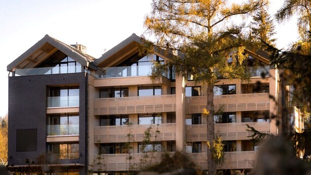 Un edificio a più piani dal design architettonico moderno, con balconi e ampie finestre.