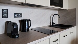 Una cucina moderna con forno a microonde integrato, macchina da caffè e un elegante lavello nero.