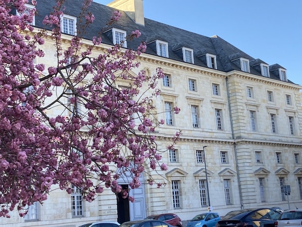 A large stone building with multiple windows and a sign reading '12 Le Stenonel.'