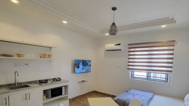 A compact living space with a kitchenette, dining area, and a sofa.