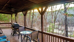 A covered deck with a grill, chairs, and a table. - Golden Trout-2 bedroom/Hot Tub/Location (Broken Bow)