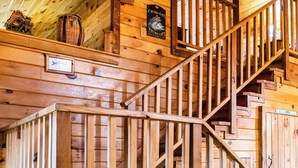 A wooden staircase with a railing, a sign for a fishing club, and a fish symbol on the wall. - Golden Trout-2 bedroom/Hot Tub/Location (Broken Bow)