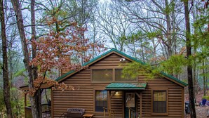 A rustic cabin with a porch, a bench, and a small table. - Golden Trout-2 bedroom/Hot Tub/Location (Broken Bow)